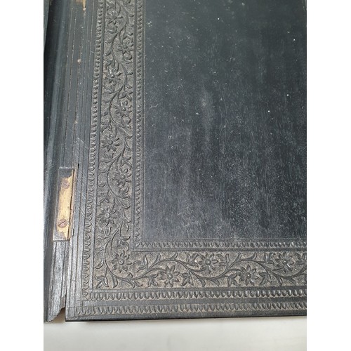 67 - An Indian ebonised hardwood Book Cover with all over carved floral decorations. (R2).