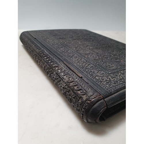 67 - An Indian ebonised hardwood Book Cover with all over carved floral decorations. (R2).