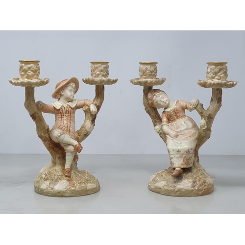 342 - A pair of Royal Worcester Hadley two branch blush Candelabra with figures of boy and girl on branch ... 