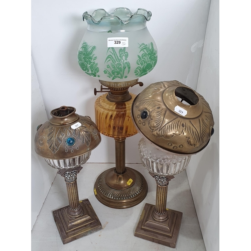 Three brass and glass Paraffin Lamps, one with etched glass shade, two ...