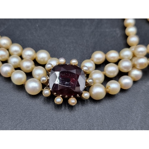 150 - A cultured pearl triple row Necklace with large garnet set clasp