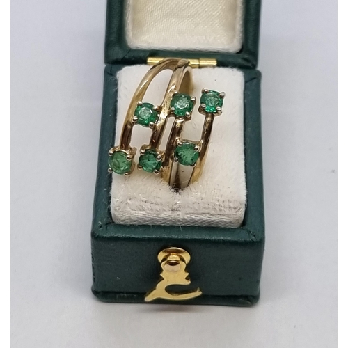 171 - An Emerald Ring peg-set six round emeralds in a cross-over setting in 9ct gold, ring size J 1/2, app... 