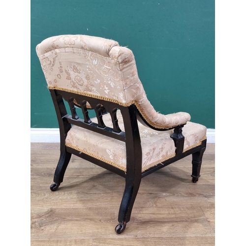 239 - An ebonised upholstered deep seated Elbow Chair with shaped spindle back, with beige floral upholste... 