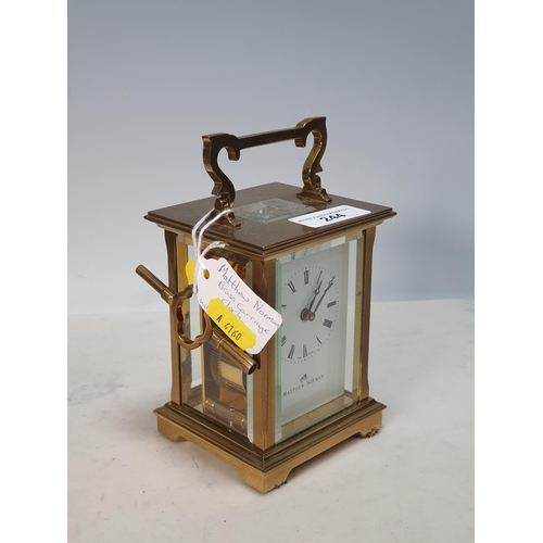 244 - A brass cased Carriage Clock by Matthew Norman with white enamel dial, 6in H including the handle