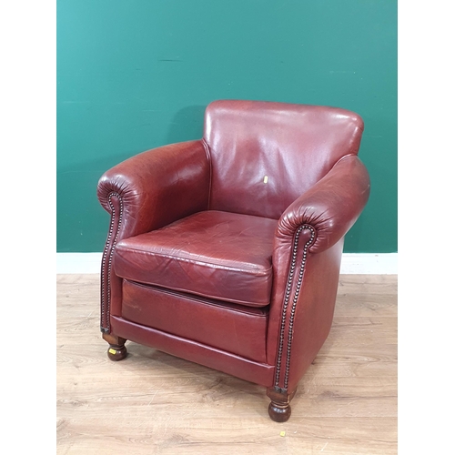 25 - A brown leather Armchair on turned feet 2ft 8in H x 2ft 8in W (R6)