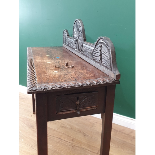 28 - An antique oak Side Table with raised back and carved frieze fitted end drawer A/F 3ft 6in W x 3ft 1... 