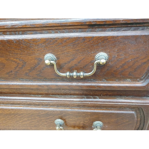 297 - A reproduction oak Chest of of three long Drawers raised on large turned bun feet, 2ft 8