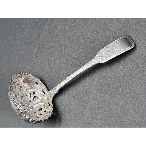 93 - A William IV silver Sifting Ladle fiddle pattern with engraved stem and fruiting vine embossed bowl,... 