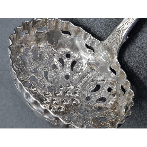 93 - A William IV silver Sifting Ladle fiddle pattern with engraved stem and fruiting vine embossed bowl,... 