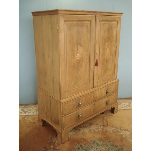 106 - A Georgian mahogany and vase inlaid Linen Press fitted pair of cupboard doors above base fitted two ... 