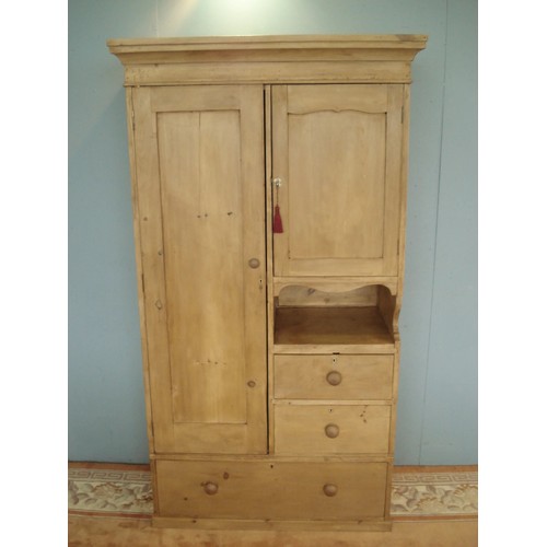 90 - An antique pine Wardrobe by James Schoolbred & Co. fitted two cupboard doors above recess and two sh... 
