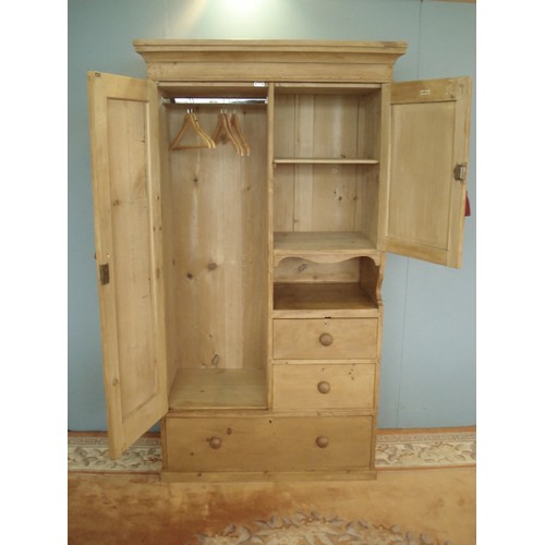 90 - An antique pine Wardrobe by James Schoolbred & Co. fitted two cupboard doors above recess and two sh... 