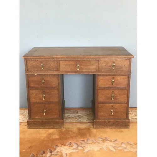 55 - An Edwardian oak Pedestal Desk with brown leather inset writing surface above nine drawers on plinth... 