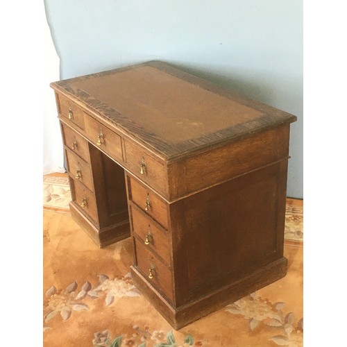 55 - An Edwardian oak Pedestal Desk with brown leather inset writing surface above nine drawers on plinth... 