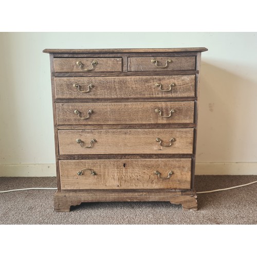 64 - An 18th Century stripped oak Chest of two short over four long graduated drawers raised on bracket f... 