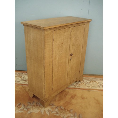 123 - An oak two door Cupboard enclosing adjustable shelves raised on bracket feet 3ft 4in H x 3ft W x 1ft... 