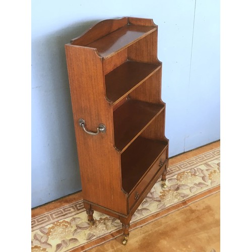 131 - A mahogany Waterfall Bookcase fitted single drawer raised on turned supports and brass casters 3ft 7... 