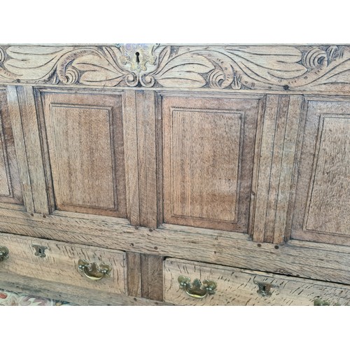 141 - An 18th Century oak Mule Chest with leafage carved frieze and  fielded three panel front above two d... 