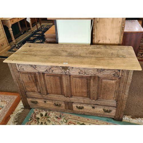 141 - An 18th Century oak Mule Chest with leafage carved frieze and  fielded three panel front above two d... 