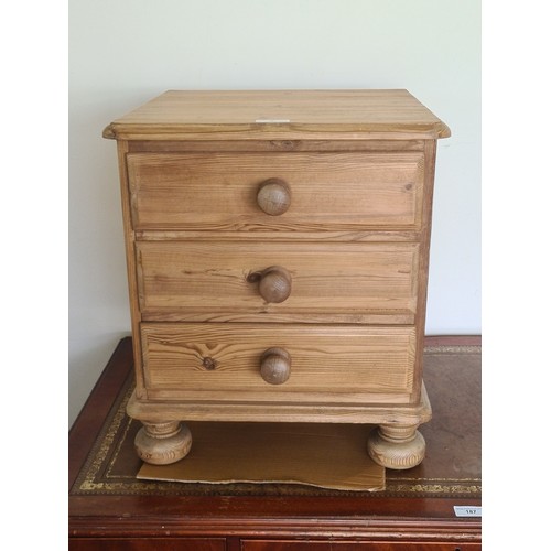 6 - A stripped pine Bedside Chest fitted three drawers raised on turned supports 1ft 9in H x 1ft 7in W