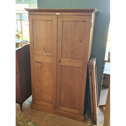 13 - A pine Housekeeper's Cupboard/Wardrobe fitted pair of panel doors on plinth base 5ft 5in H x 3ft 3in... 