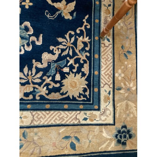 107 - A Chinese style blue ground Carpet with floral design within pink border with design of trailing flo... 