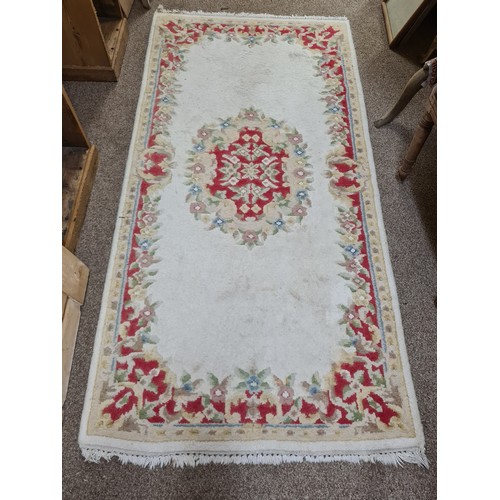 180 - A red ground Chinese style Rug 7ft 8in L x 5ft 10in W and a cream ground Rug 6ft 4in L x 3ft 1in W