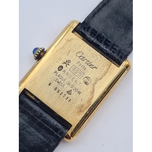 129 - A lady's Must de Cartier manual wind Tank Wristwatch the rectangular black dial with gold hands, sap... 