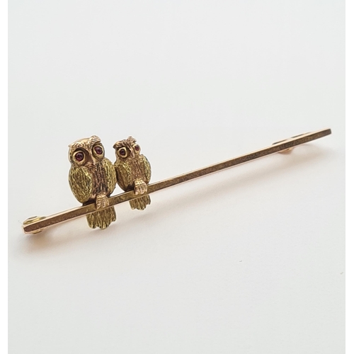 147 - An Owl Bar Brooch the simple bar with two birds set ruby cabochon eyes, stamped 9ct, approx 49mm lon... 