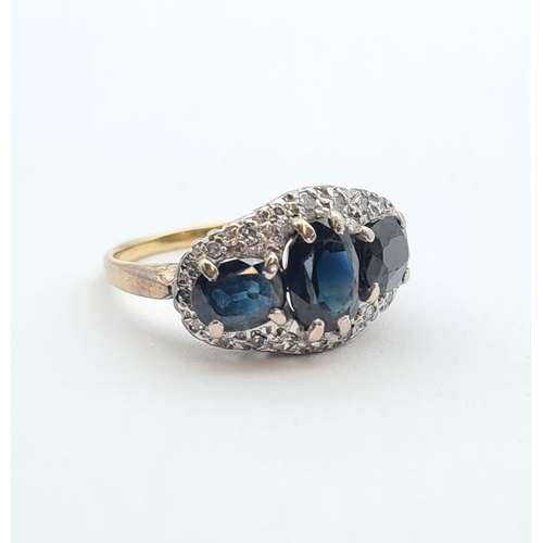 170 - A Sapphire and Diamond Cluster Ring claw-set three oval-cut sapphires within a frame of illusion-set... 