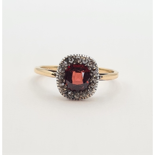 173 - A Garnet and Diamond Cluster Ring set cushion-cut garnet within frame of old-cut diamonds in 18ct go... 