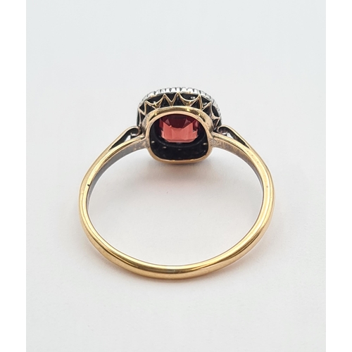 173 - A Garnet and Diamond Cluster Ring set cushion-cut garnet within frame of old-cut diamonds in 18ct go... 