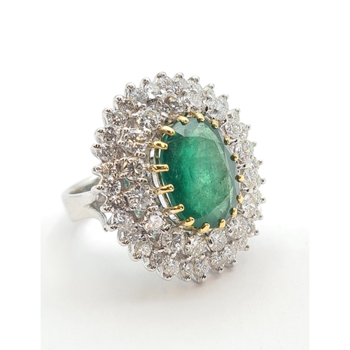 195 - An Emerald and Diamond Cocktail Ring claw-set oval-cut emerald, 6.45cts, within double frame of bril... 