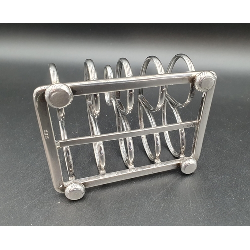 2 - A Victorian silver five bar Toastrack with central handle engraved crest, on bun feet, London 1869, ... 