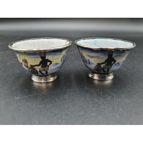 21 - A pair of silver mounted small enamel Bowls decorated African tribal figures with shields, floral ce... 