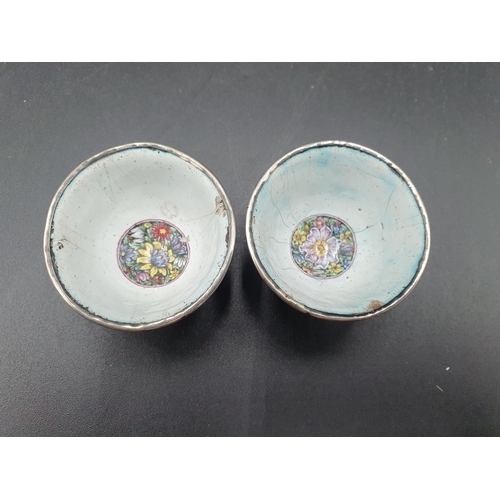 21 - A pair of silver mounted small enamel Bowls decorated African tribal figures with shields, floral ce... 