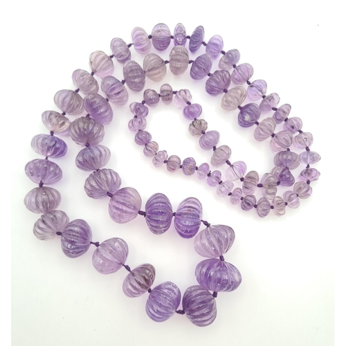 217 - An Indian graduated melon carved Amethyst Bead Necklace, approx 88cms long