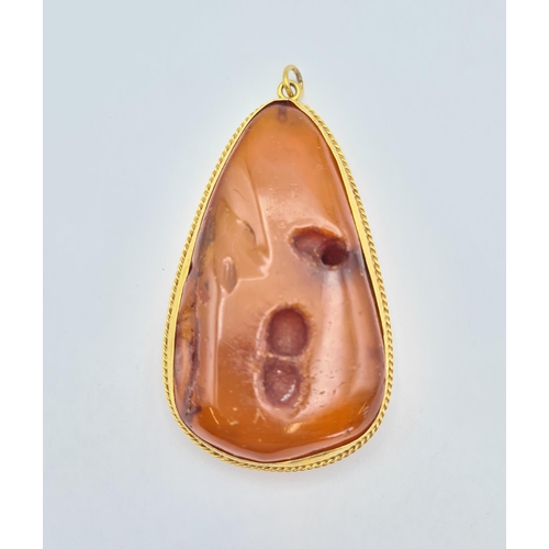 219 - A large Amber Pendant in gold rope twist frame, approx 8.5cms long