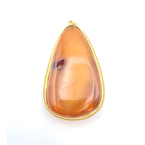 219 - A large Amber Pendant in gold rope twist frame, approx 8.5cms long