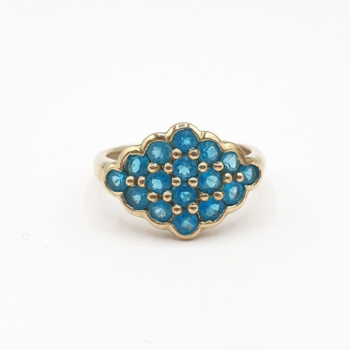 187 - A Cluster Ring having lozenge shaped plaque set round stones, possibly apatite, in 9ct gold, ring si... 