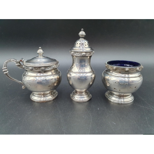 56 - An Elizabeth II silver three piece circular Condiment Set with celtic style friezes, Birmingham 1956