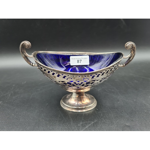 87 - An Edward VII silver two handled pierced oval Bowl with blue glass liner on pedestal base, Birmingha... 