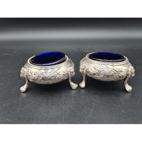 88 - A pair of Victorian silver Cauldron Salts with floral embossing and engraved crests on lion mask and... 