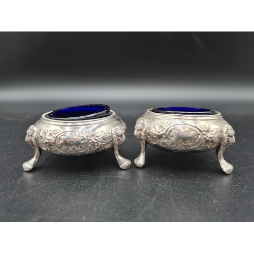 88 - A pair of Victorian silver Cauldron Salts with floral embossing and engraved crests on lion mask and... 