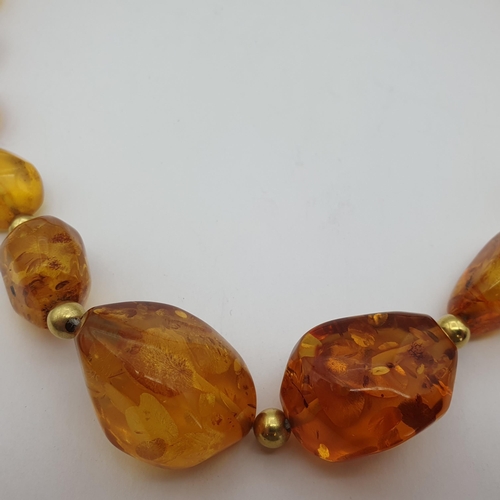 164 - A modern Amber graduated Necklace formed from irregular beads with gold bead spacers between, approx... 