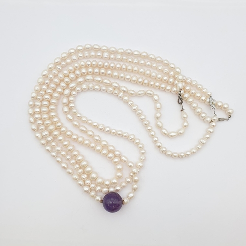 184 - Three opera length strings of Cultured Freshwater Pearls, one with large amethyst bead to front