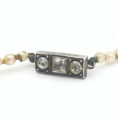 192 - A string of graduated Cultured Pearls on clasp stamped STERLING SILVER set paste