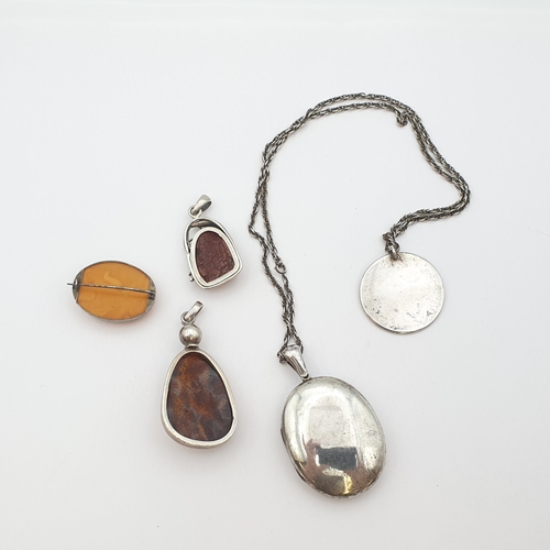 203 - An oval silver Locket and circular Pendant, two modern Amber Pendants set in silver and an oval Ambe... 