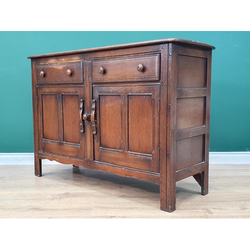 558 - An Ercol dark elm Sideboard with two fitted drawers above pair of panelled doors, 33