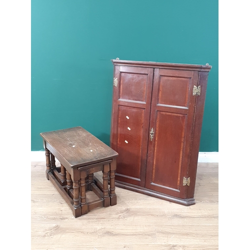 563 - An oak hanging Corner Cupboard with pair of panelled doors enclosing shaped shelves, 3ft 4